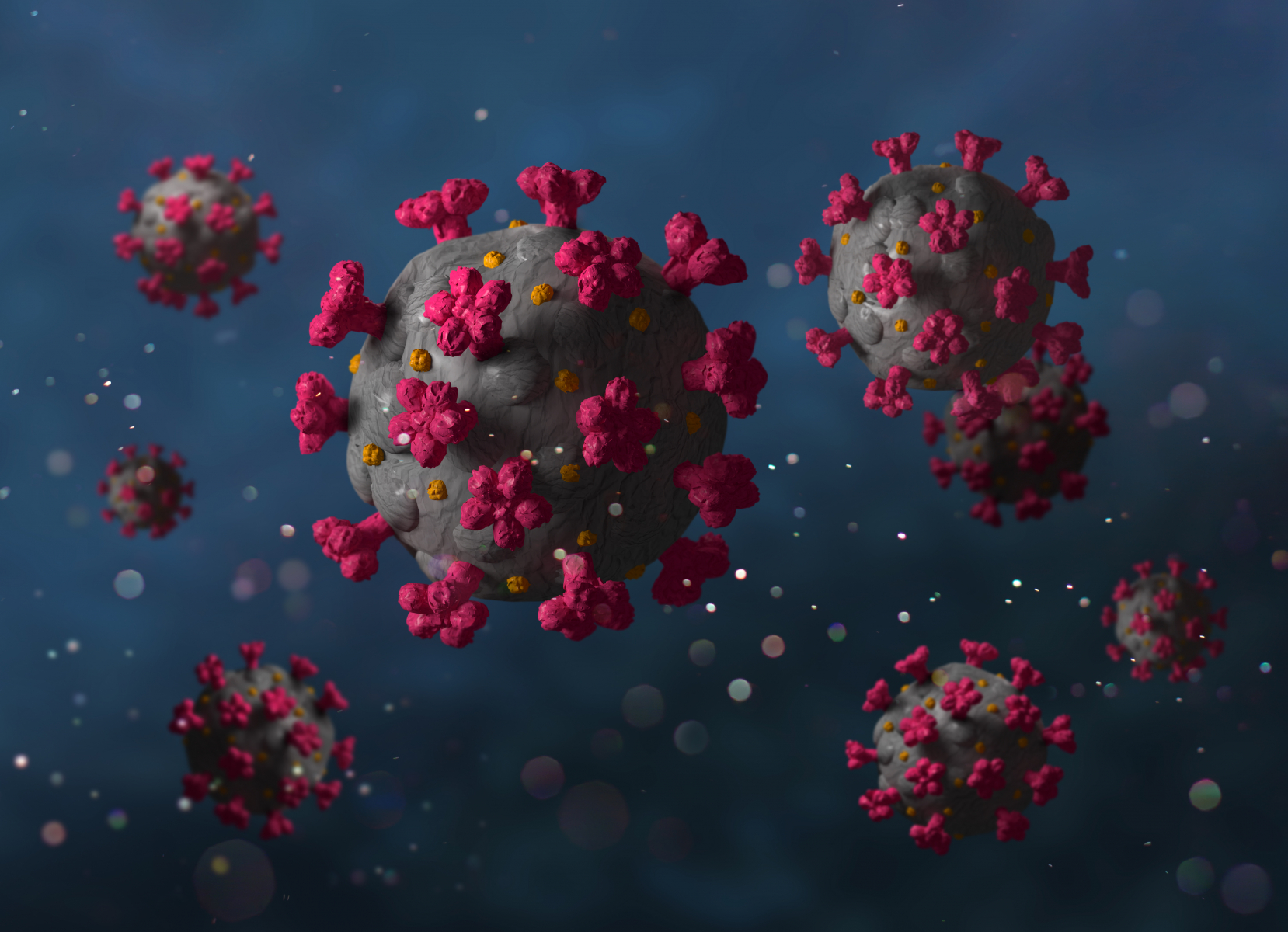 Bild på coronaviruset som en grå boll med utstickande röda flärpar i ett fång av fler virusbollar