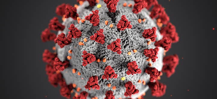En närbild på coronaviruset - en röd kula med röda utståendetintakler