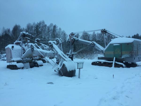 Flera grävmaskiner under ett täcke av vit snö