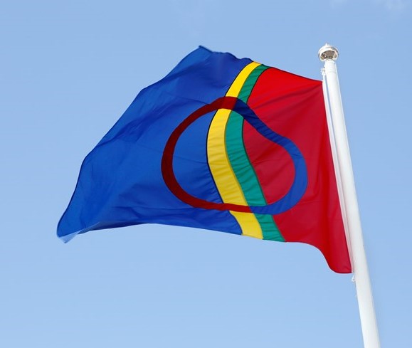 Samiska flaggan i gult, grönt blått och rött vajar i vinden
