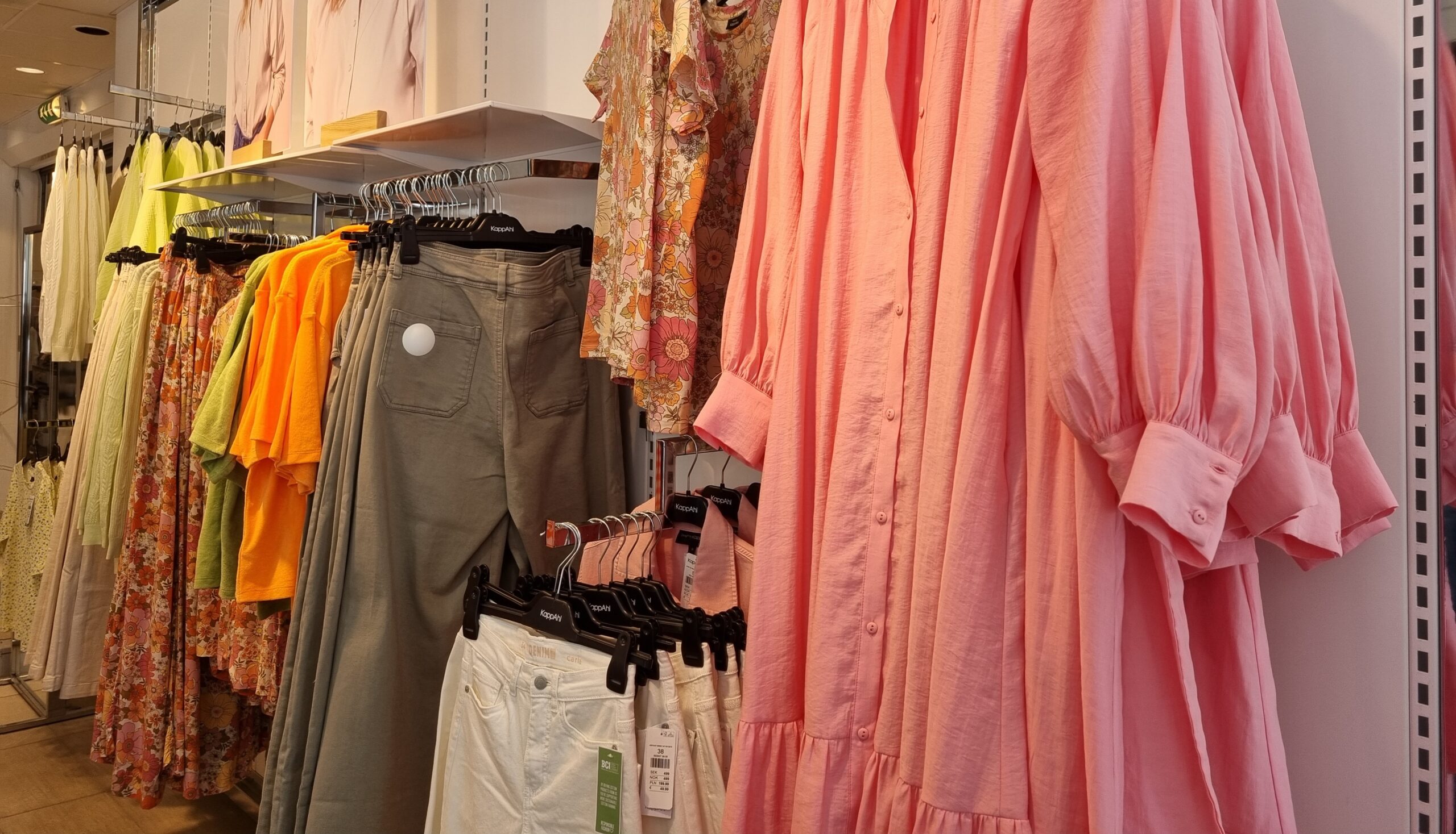 Stora skjortor, kavajer och vida byxben i knalliga färger hänger i butiken