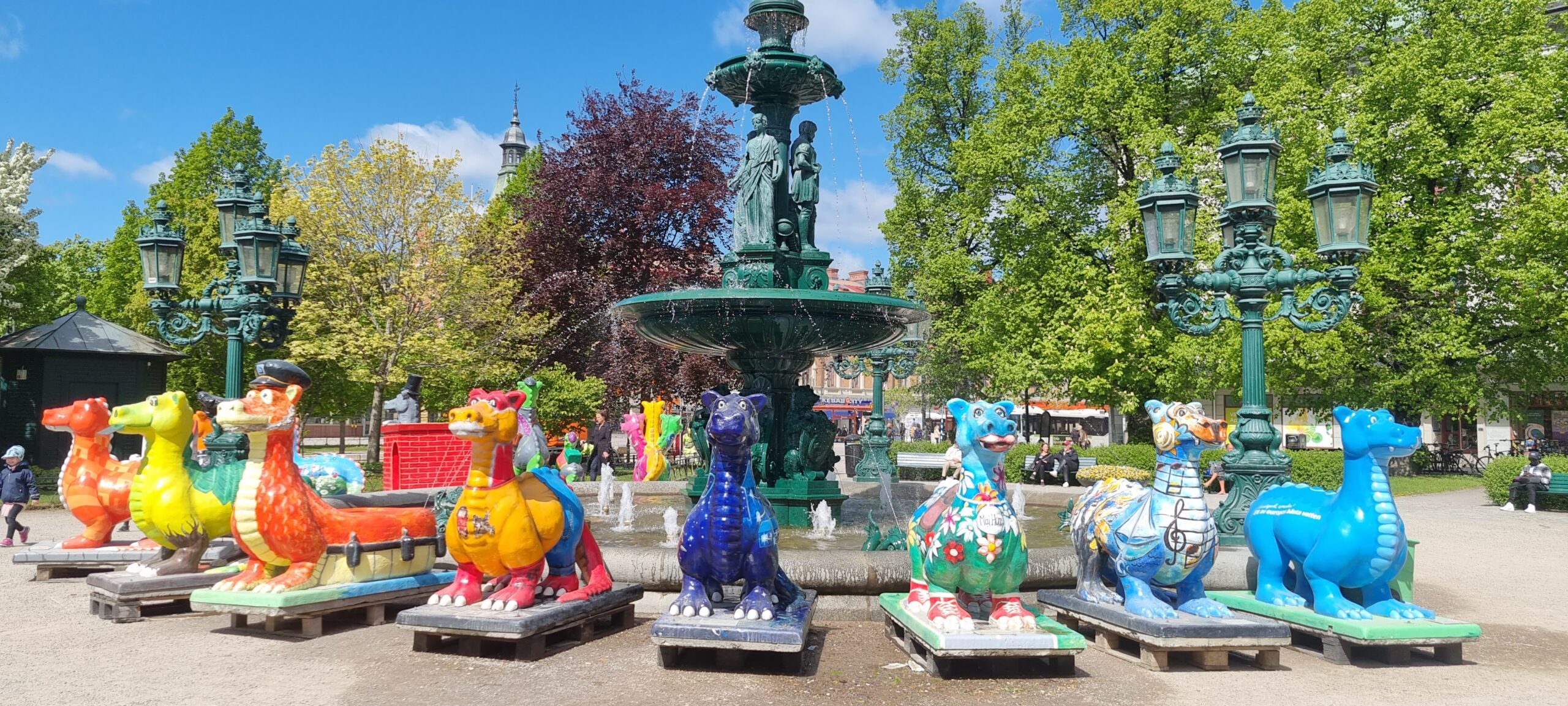 Alla färgglada drakar uppställda runt fontänen i Vängåvan
